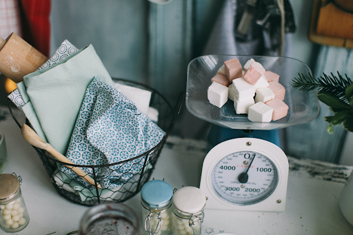 If you're wondering about how to count calories for weight loss, a kitchen scale is a useful tool. In this image, an analog kitchen scale measures a handful of sugar cubes.